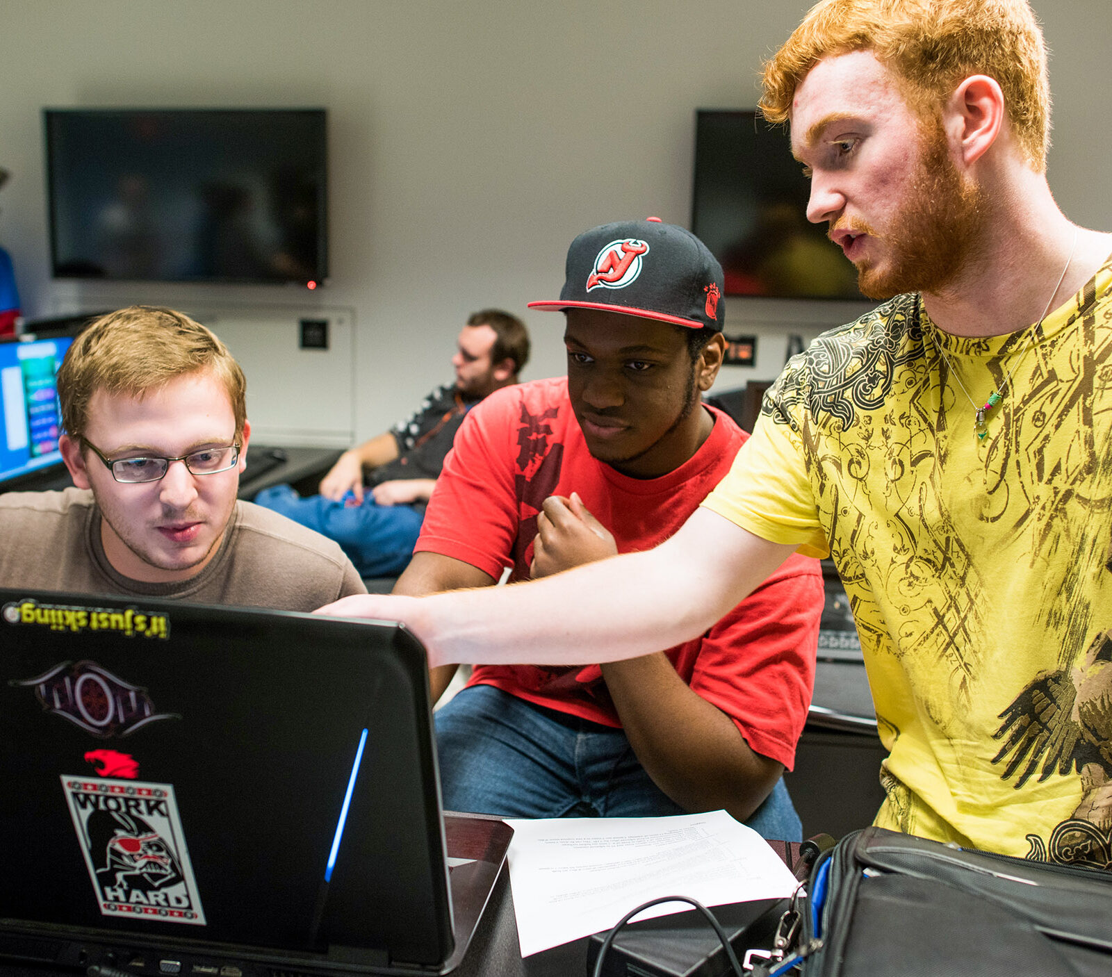 students collaborate pointing at a computer