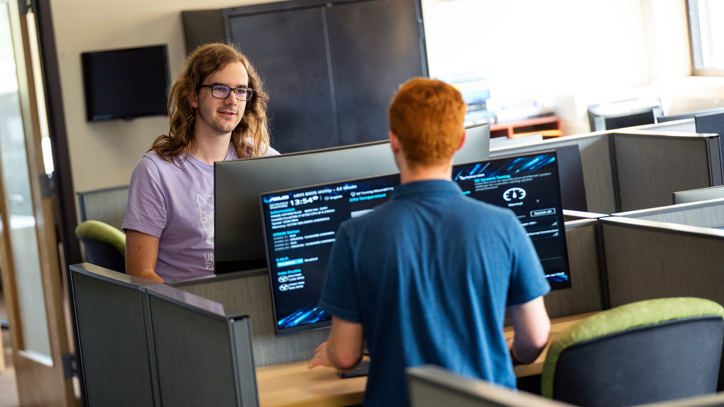 student smiles behind a computer