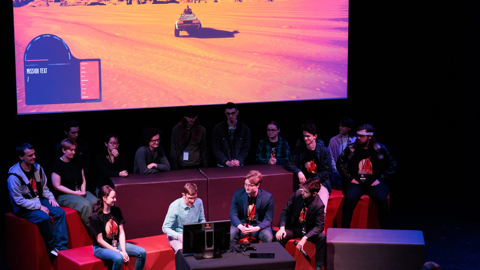 students presenting their finished game at the senior game show on stage in the auditorium