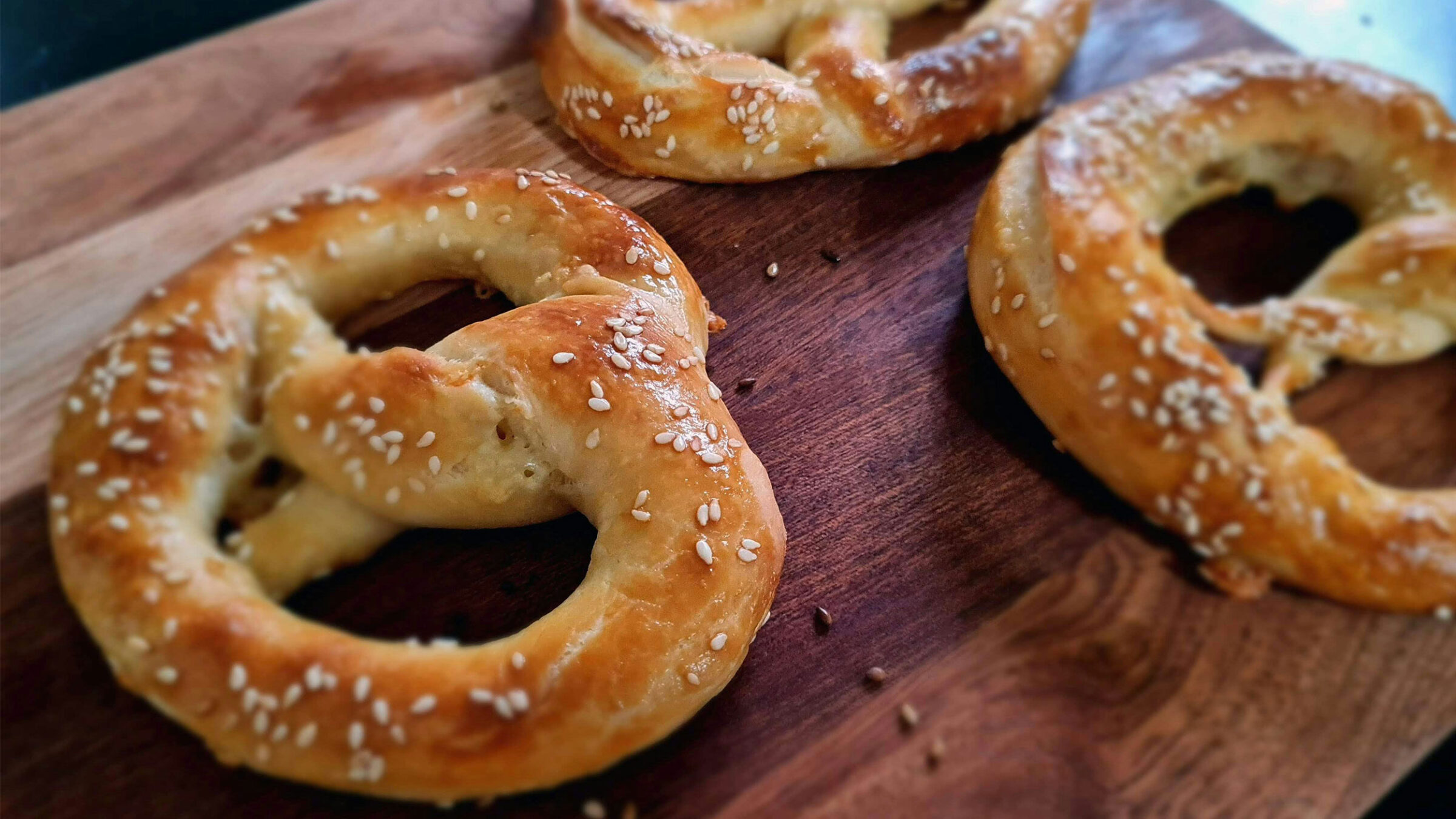 three jumbo pretzels on a cutting board
