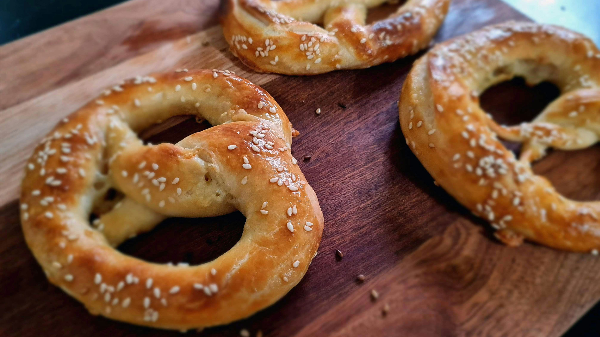 three jumbo pretzels on a cutting board