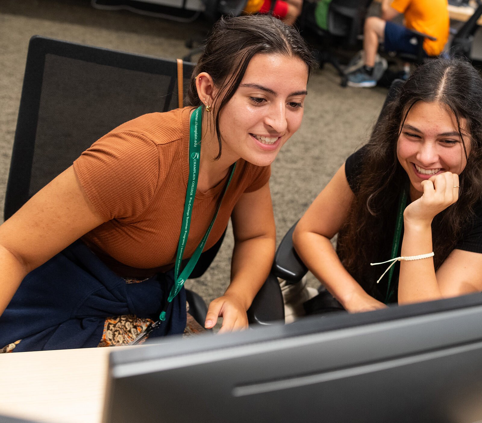 two high school students collaborate at a computer