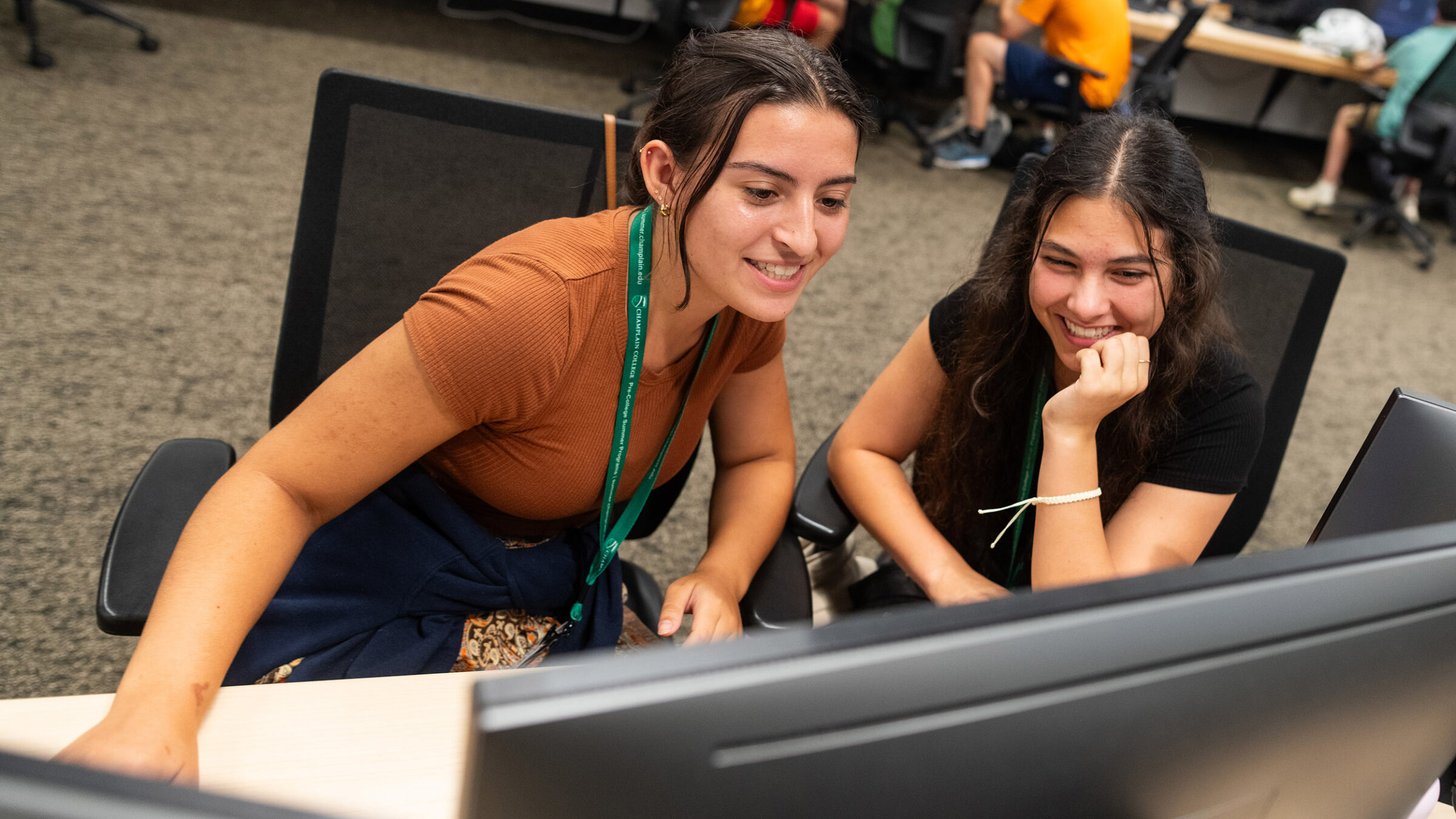 two high school students collaborate at a computer