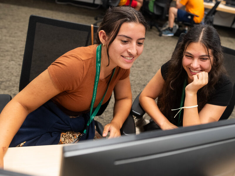 two high school students collaborate at a computer