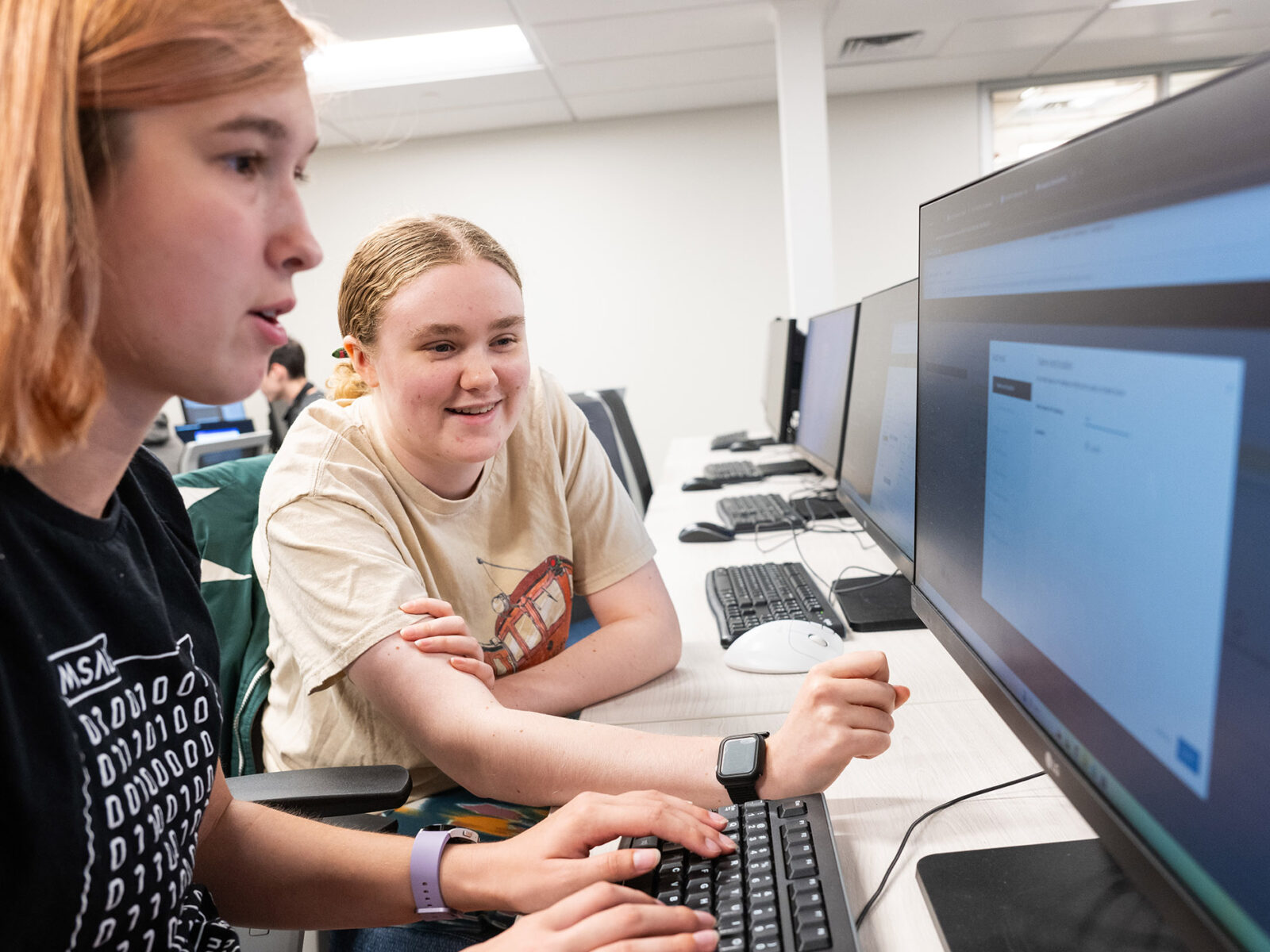 two school students collaborate at a computer