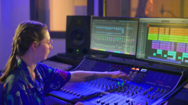 Student mixing audio using professional equipment