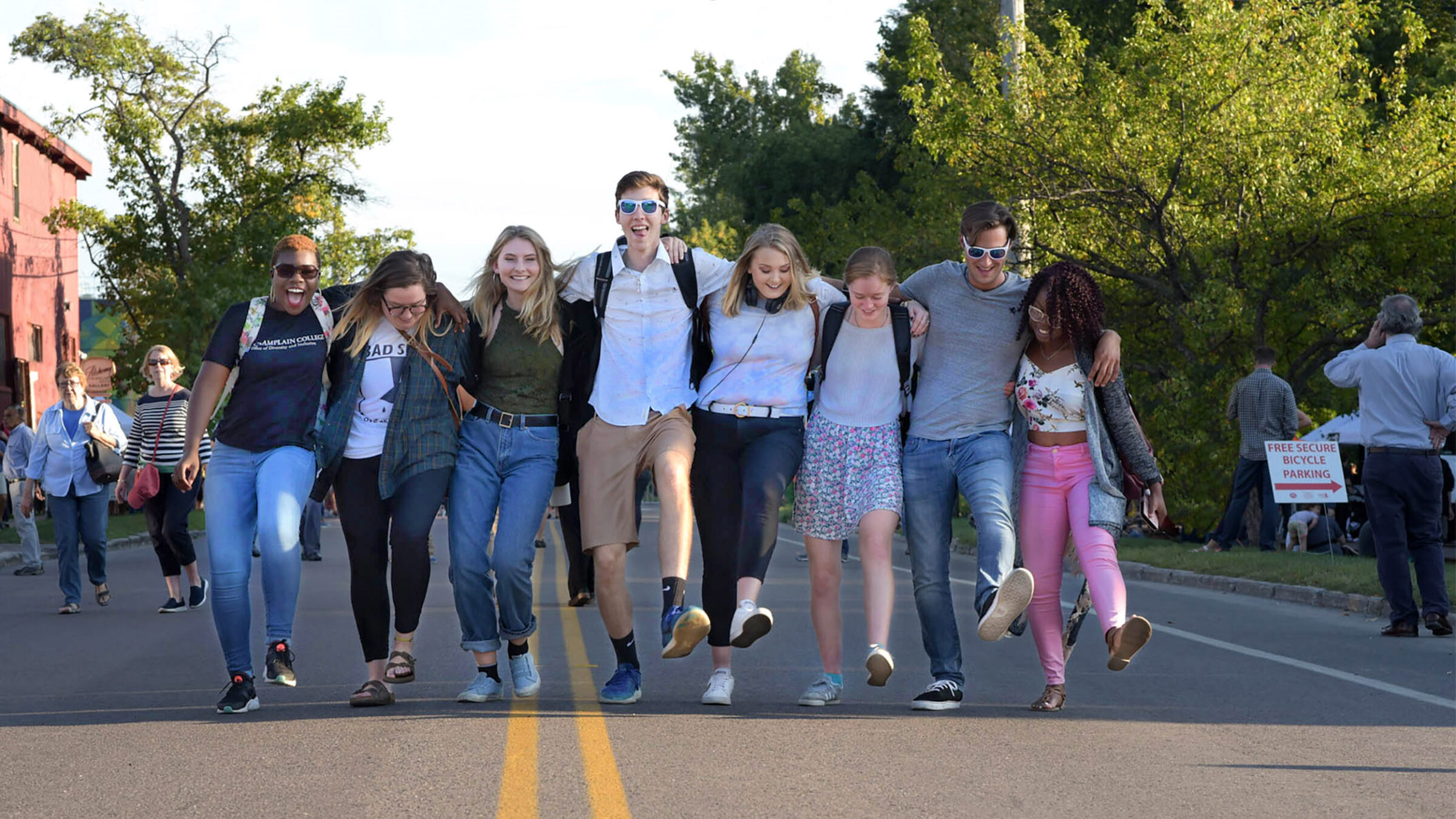 a group of students walking in a line across a street with their arms linked together behind their backs