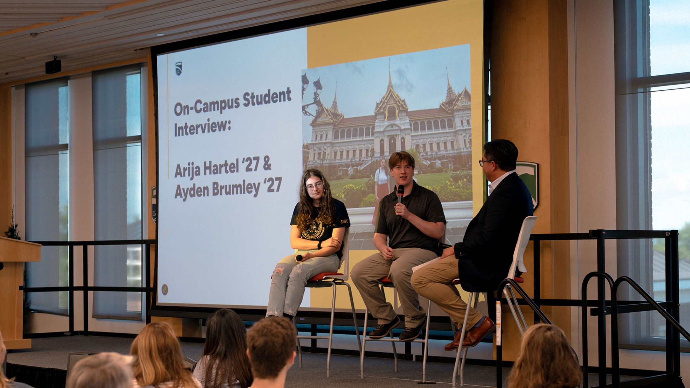Champlain students Arija Hartel and Ayden Brumley sit on stage with Alex Hernandez for a conversation about their internship in Bangkok, Thailand.