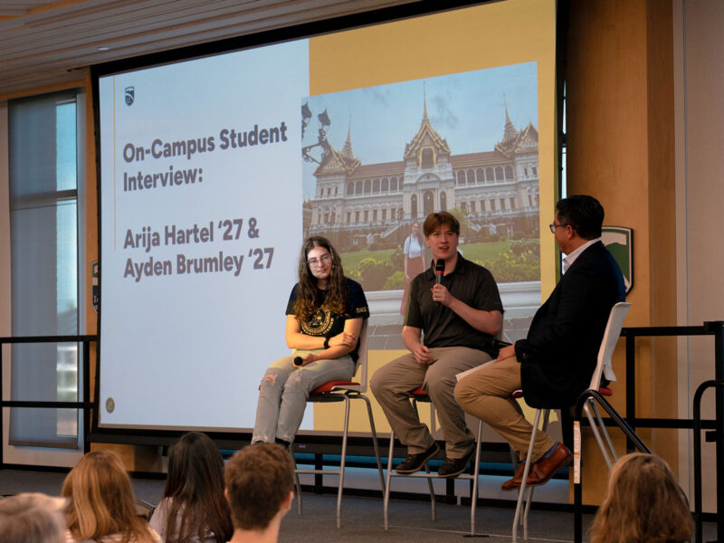 Champlain students Arija Hartel and Ayden Brumley sit on stage with Alex Hernandez for a conversation about their internship in Bangkok, Thailand.