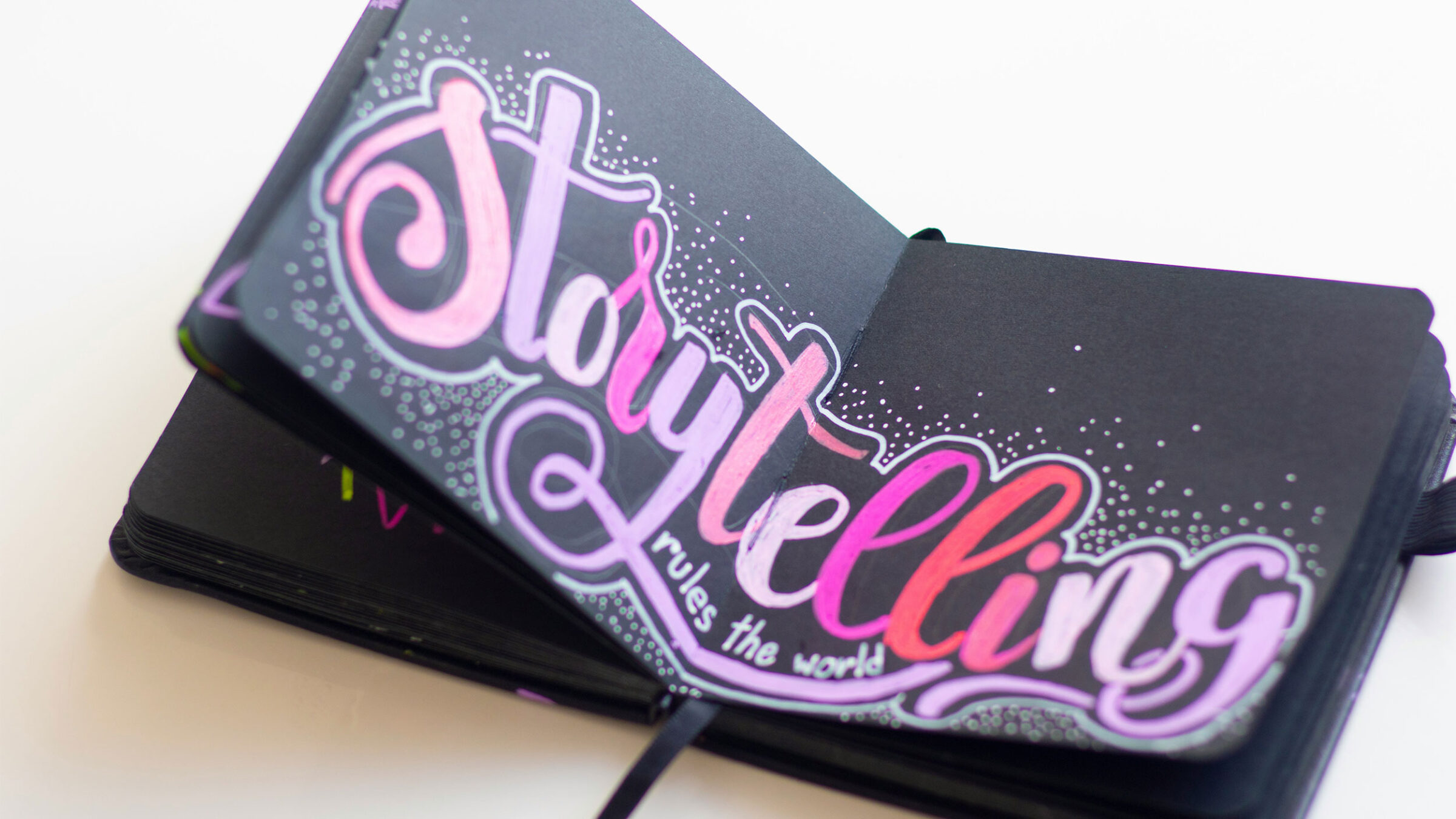 notebook that reads "storytelling" in pink letters