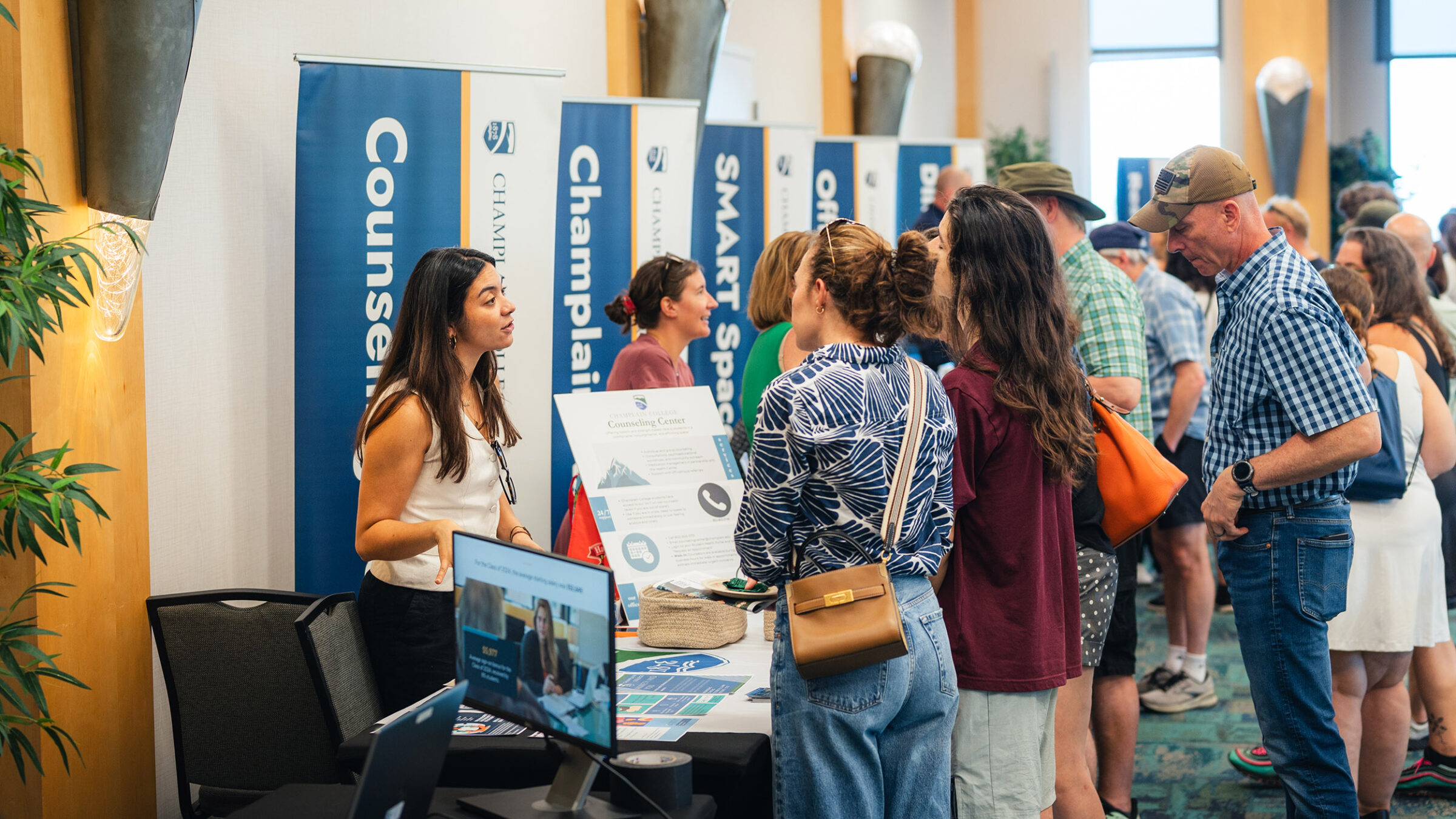 families at summer open house ask questions of Champlain College staff at information fair