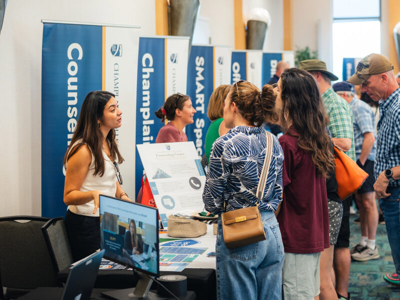 families at summer open house ask questions of Champlain College staff at information fair