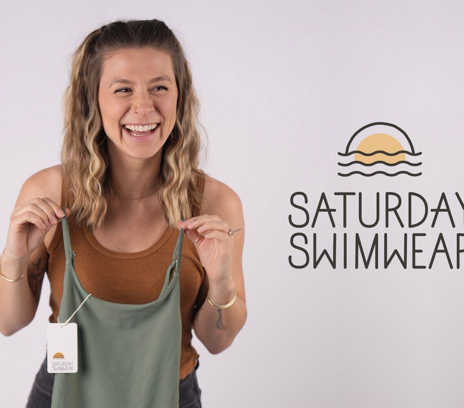 Emily holding a swimsuit next to the Saturday Swimwear logo