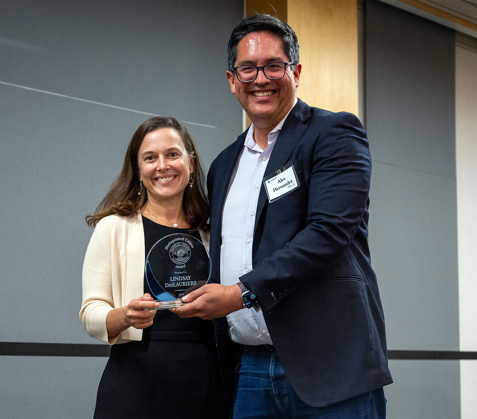 lindsey deslauriers and alex hernandez smile at camera as lindsey is awarded