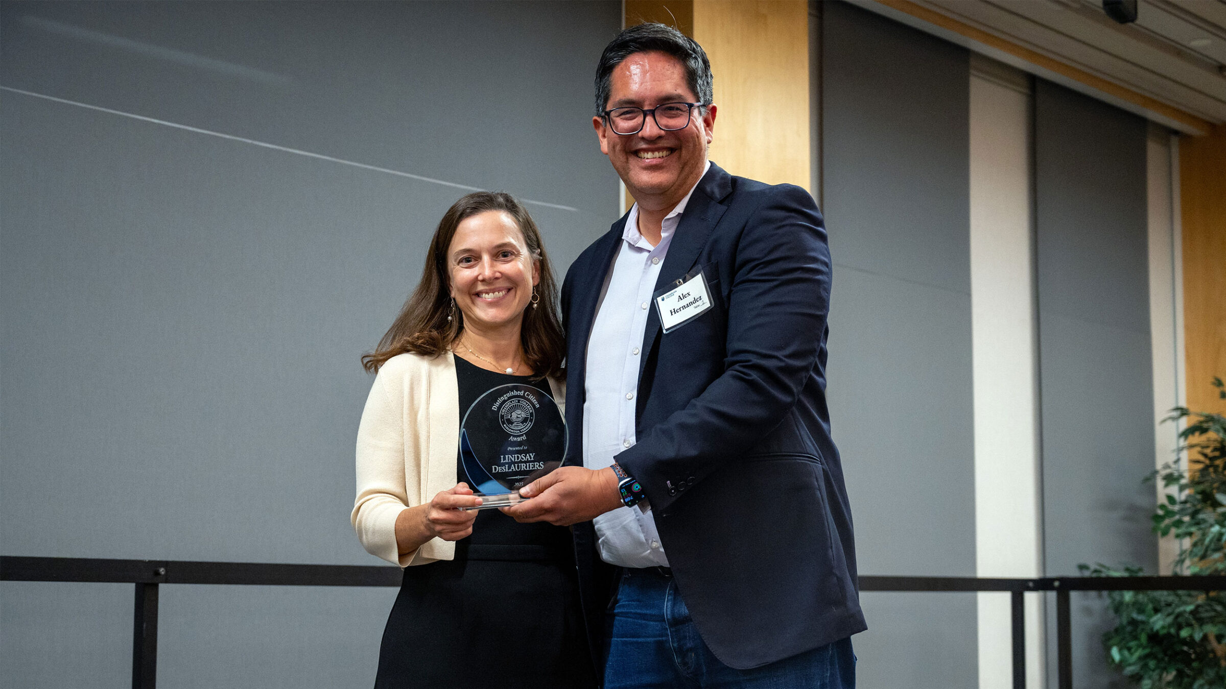 lindsey deslauriers and alex hernandez smile at camera as lindsey is awarded