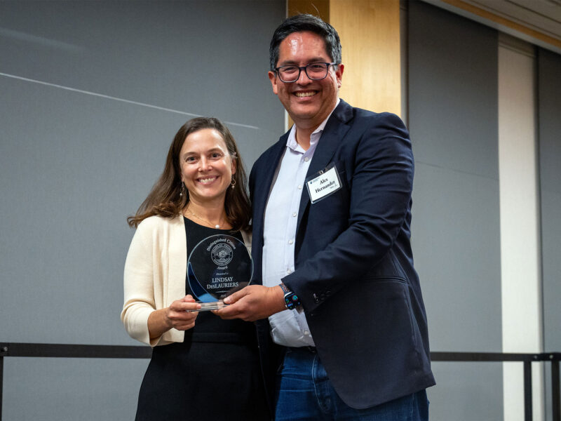 lindsey deslauriers and alex hernandez smile at camera as lindsey is awarded