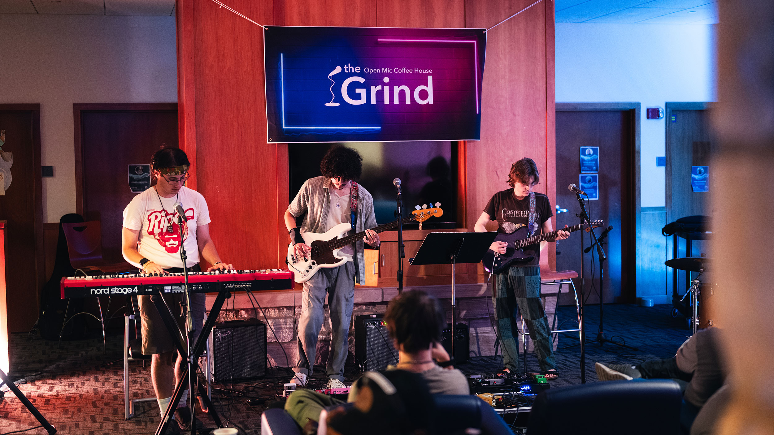 three students perform music at the grind