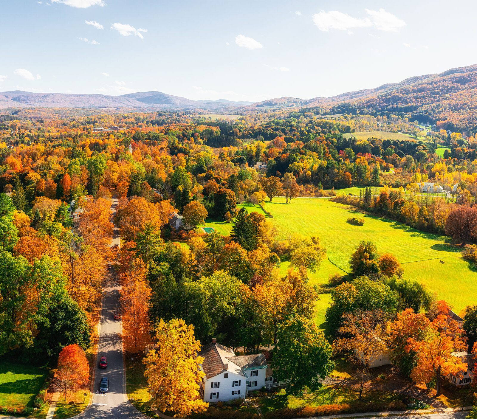 foliage landscape in vermont with mountains. orange, yellow, and red leaves on trees