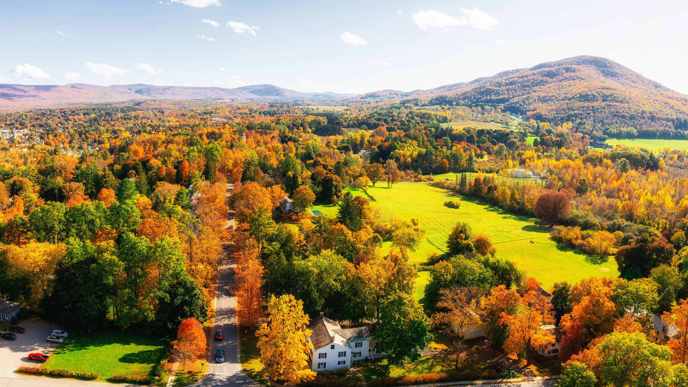 foliage landscape in vermont with mountains. orange, yellow, and red leaves on trees