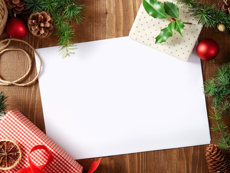 holiday card with greener and ornaments around it