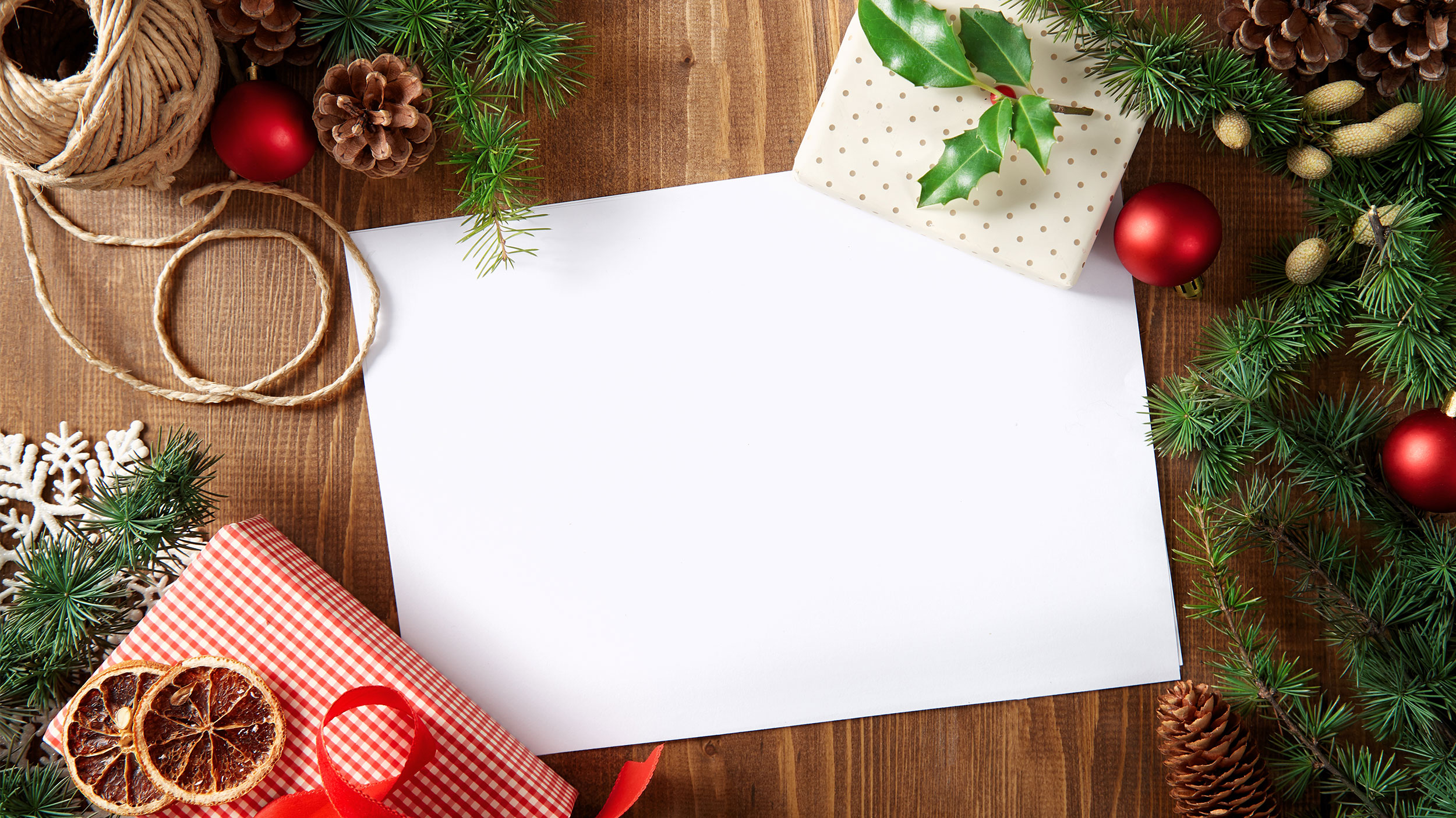 holiday card with greener and ornaments around it