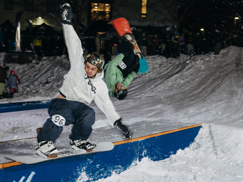snowboarder rides a rail in the snowy finney quad