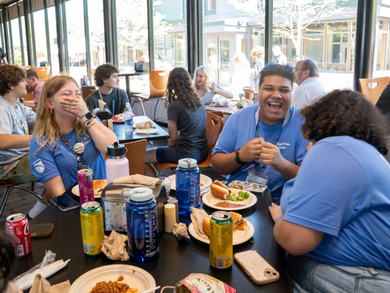 students eating and laughing in the dining hall