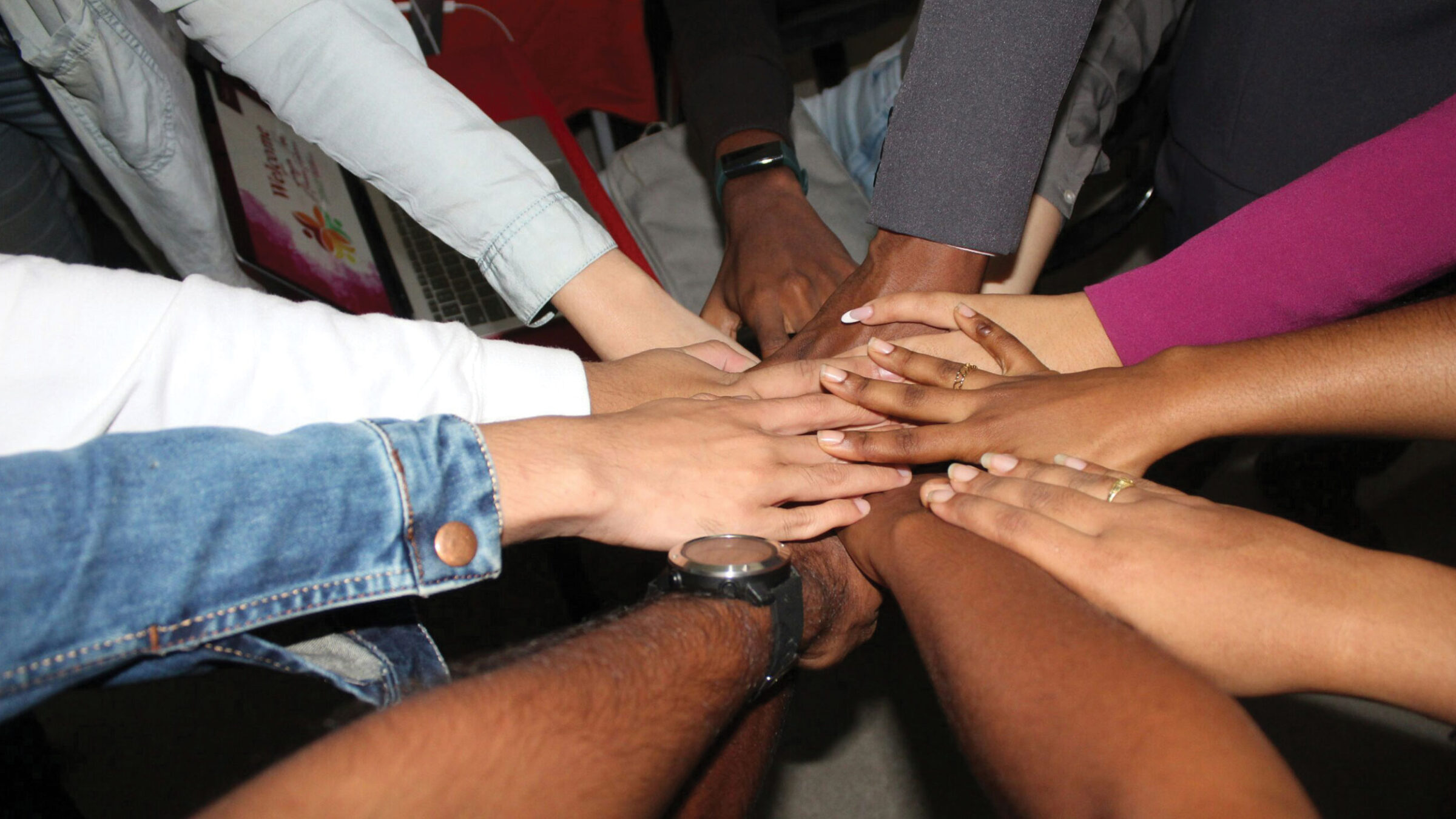 10 people's hands coming together for a cheer