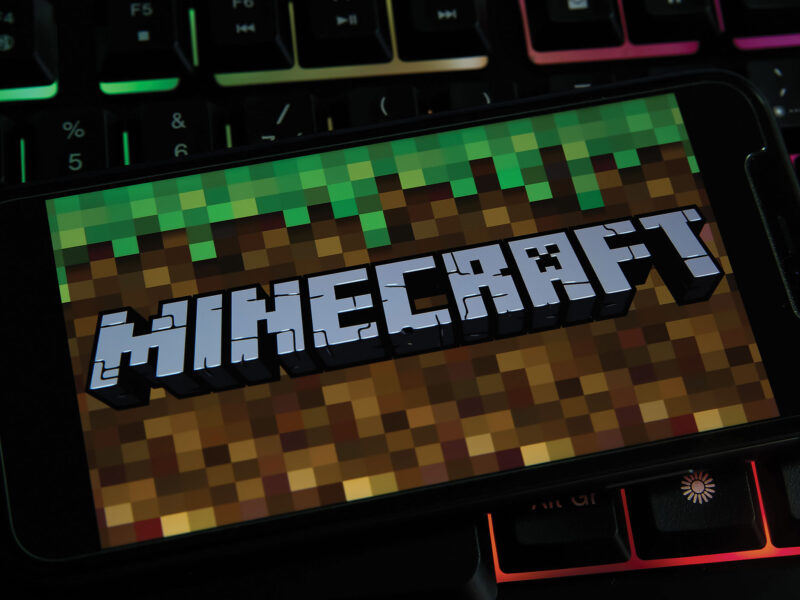 minecraft game opens on a phone atop a rainbow keyboard