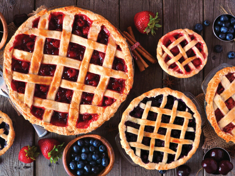 assortment of pies and fruits on wooden table