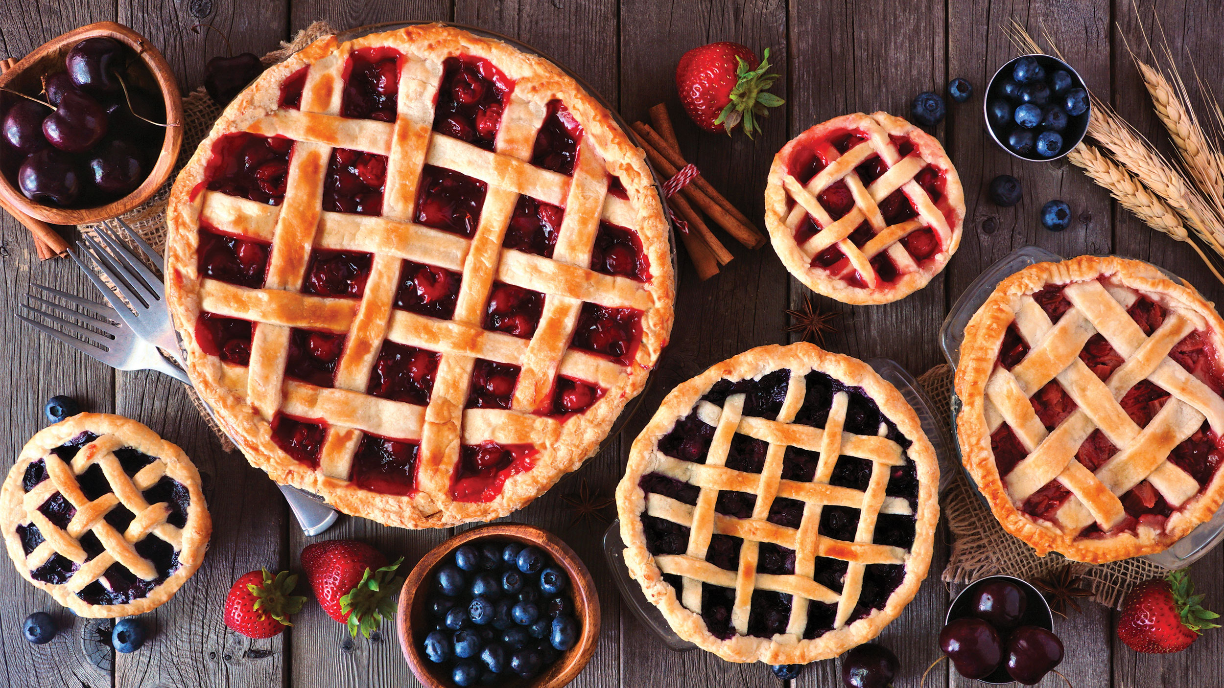 assortment of pies and fruits on wooden table
