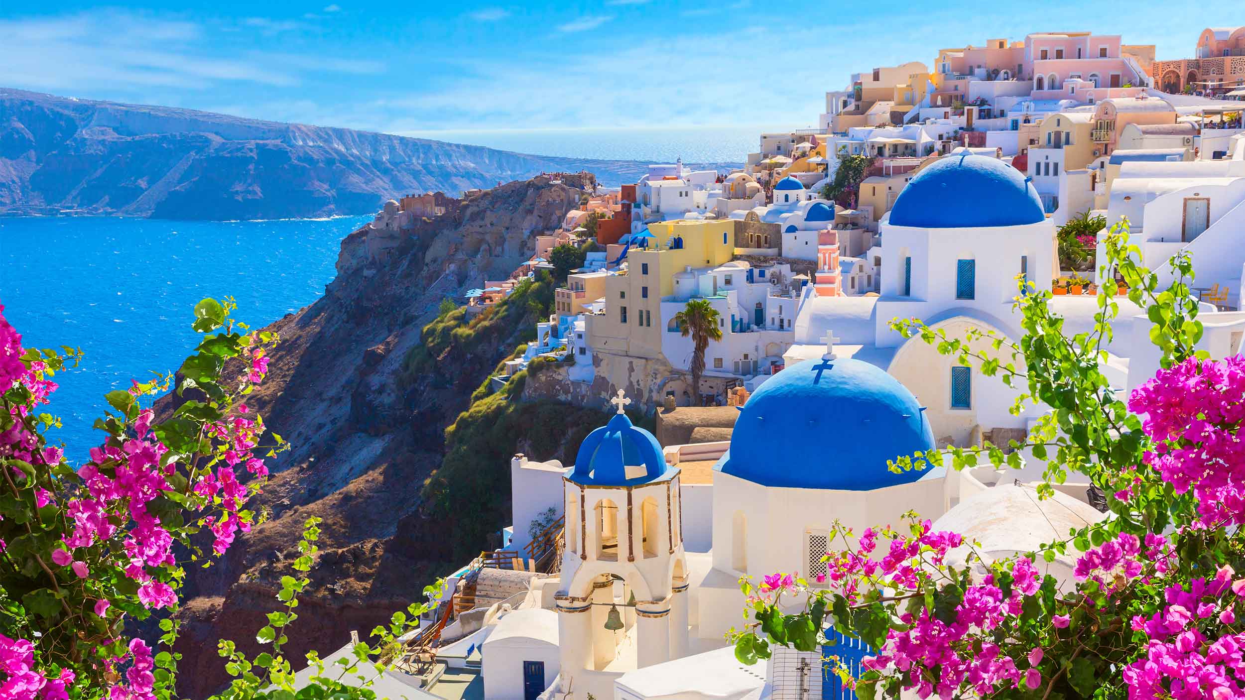 a vibrant scene of a city in greece built into the rocky coast