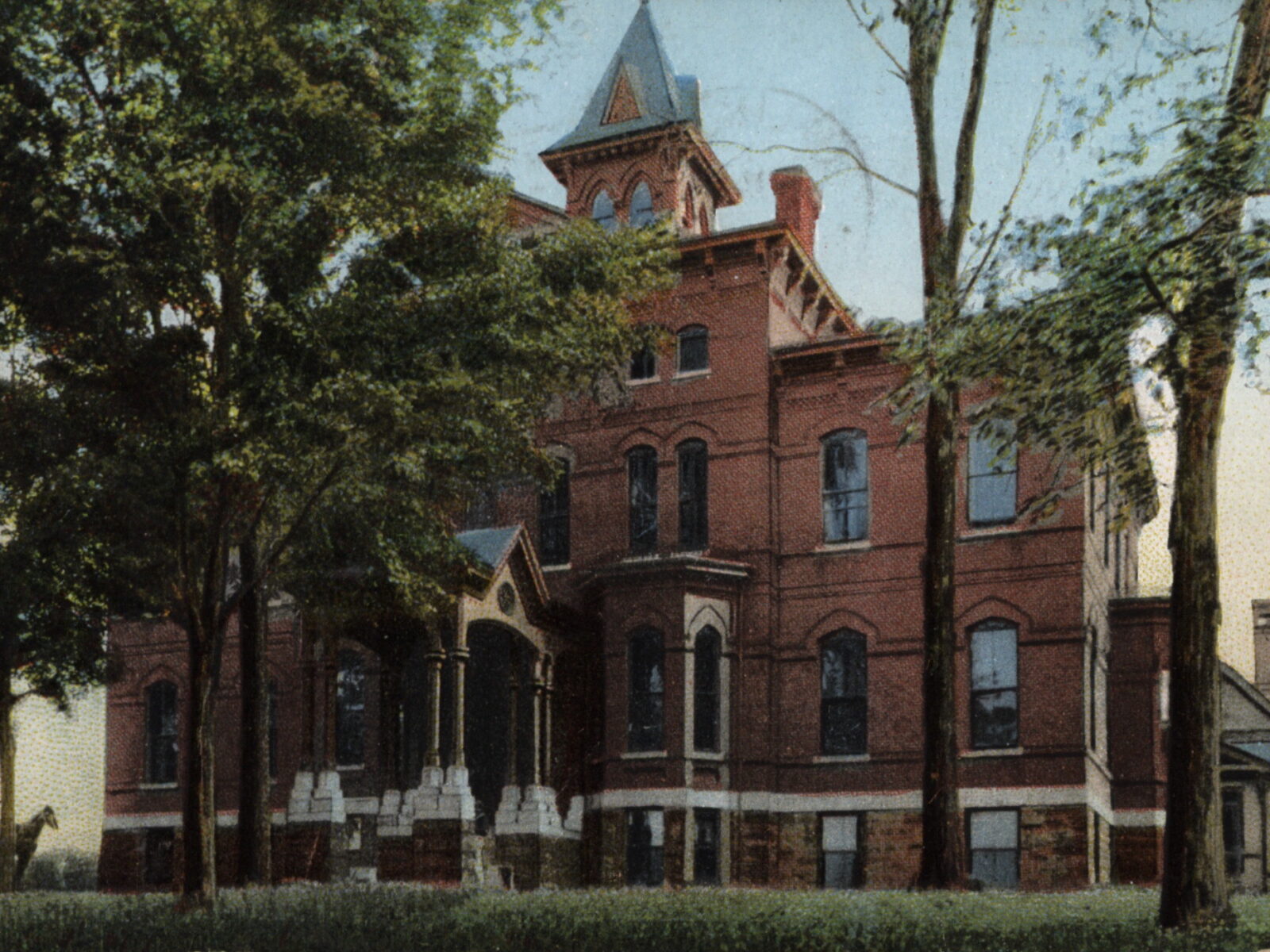 Colorized postcard (circa 1906–1909) of Mary Fletcher Hospital in Burlington, VT, showing the Italianate brick building with cupola, porte cochere, and surrounding trees.