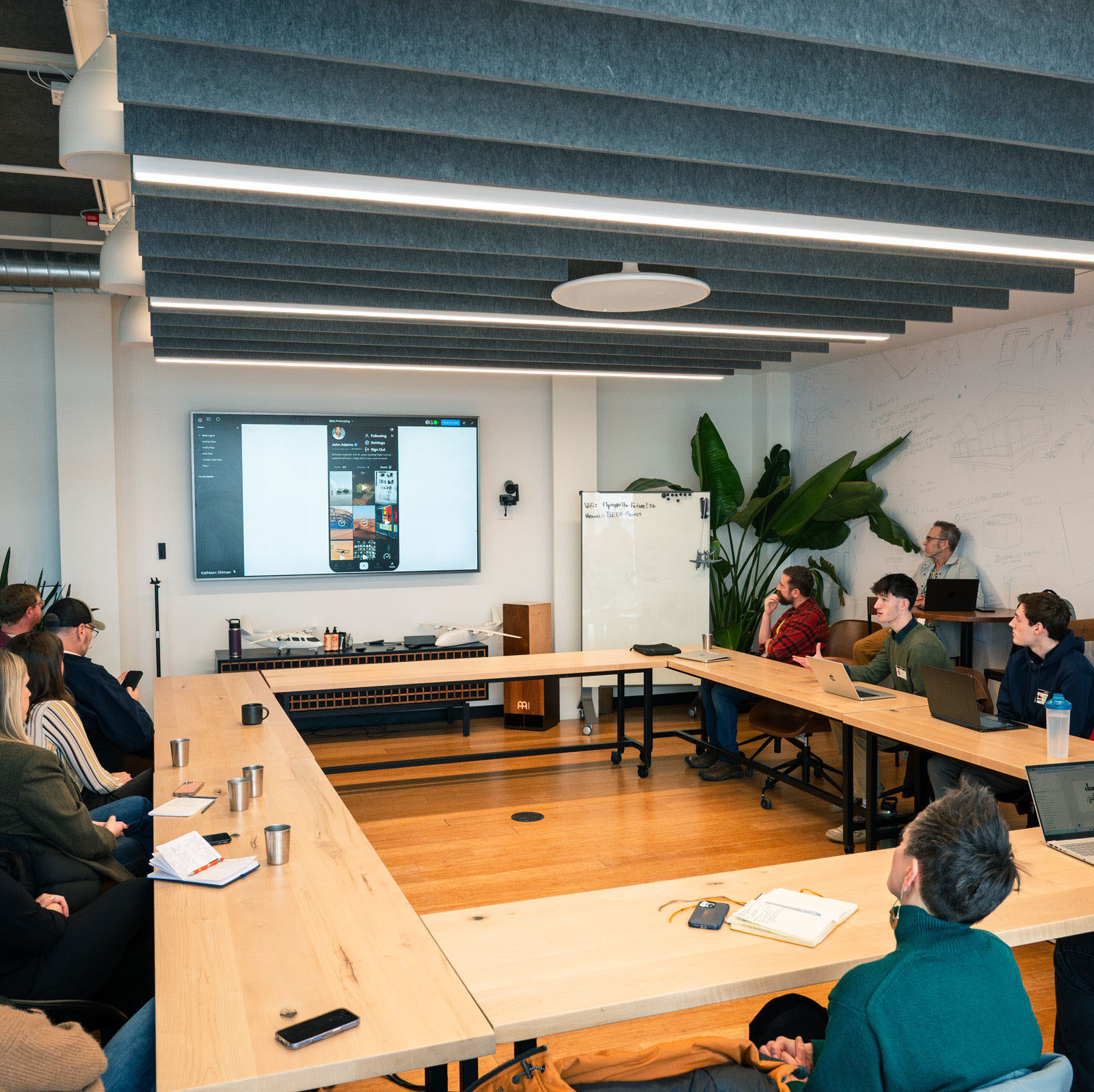 Students presenting at a conference with people around a large table