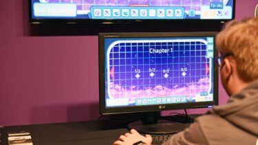 a student playing a game on a computer with purple lighting