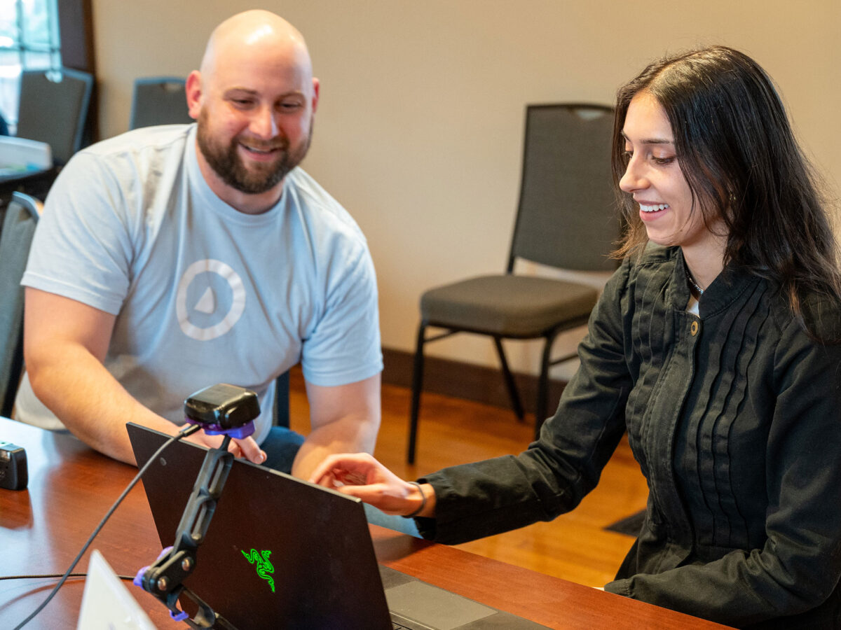 A staff member from OVR Technology walks Champlain College staff member through a demo of their new Omara device.