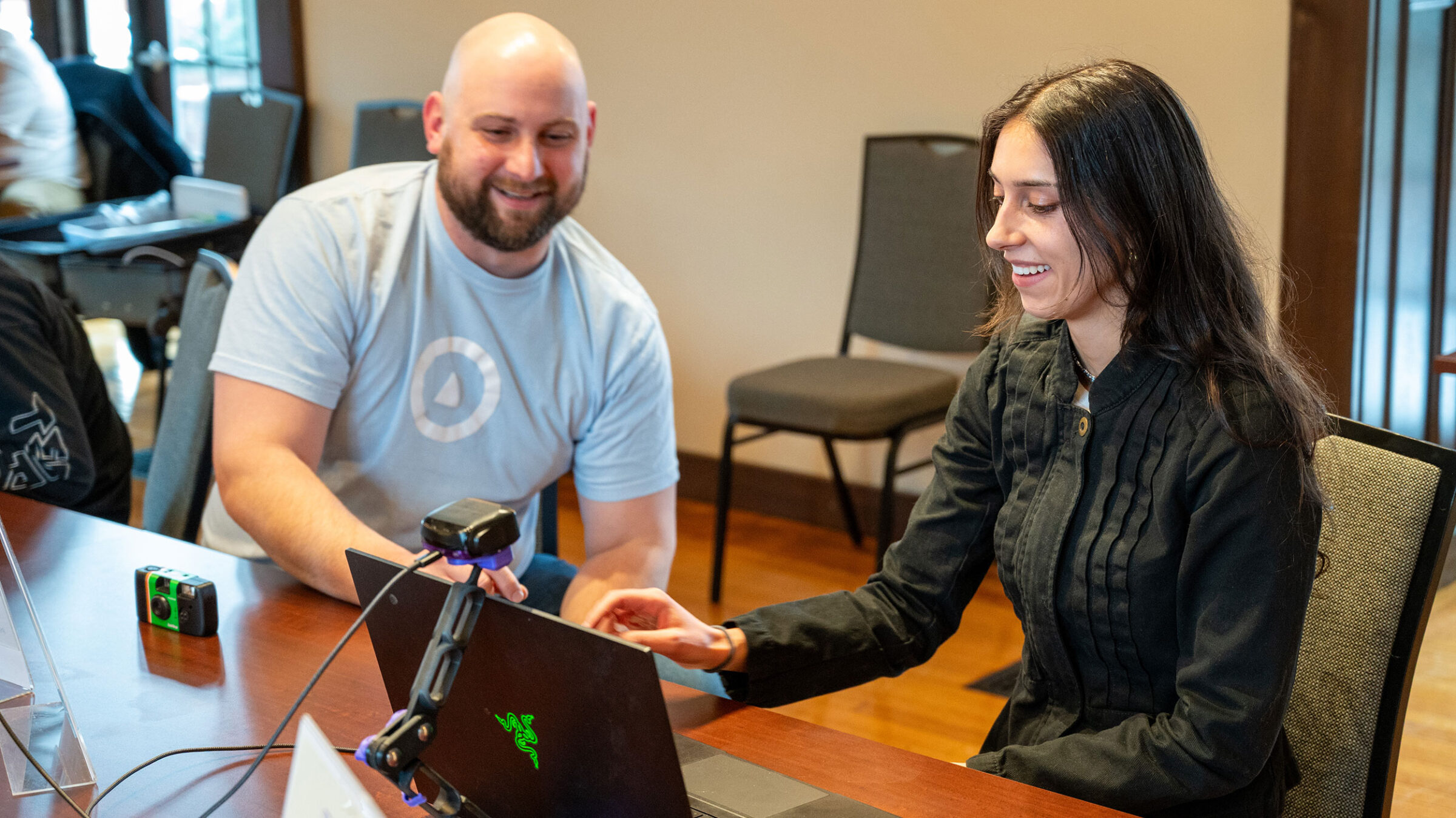 A staff member from OVR Technology walks Champlain College staff member through a demo of their new Omara device.