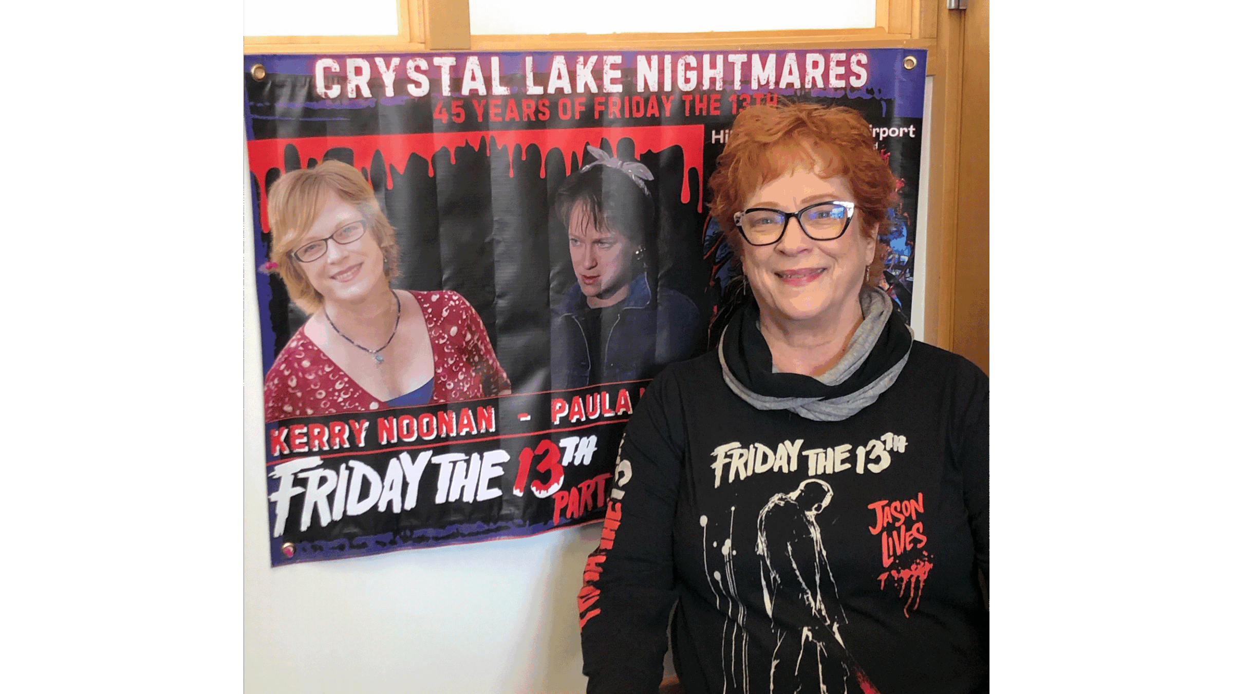 Professor Kerry Noonan poses in front of a Friday the 13th movie poster, featuring her as Paula in the film.