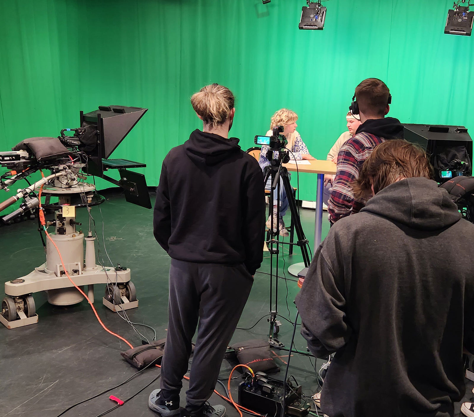 a group of students broadcasting in front of a green screen at Champlain's film stage with cameras and mics