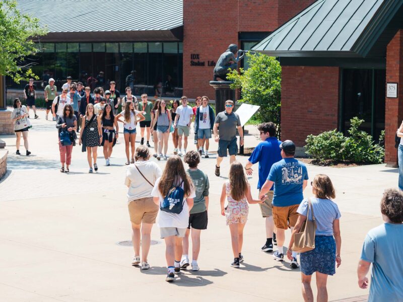 Prospective students and families visiting campus in the Summer, walking around near IDX in the courtyard