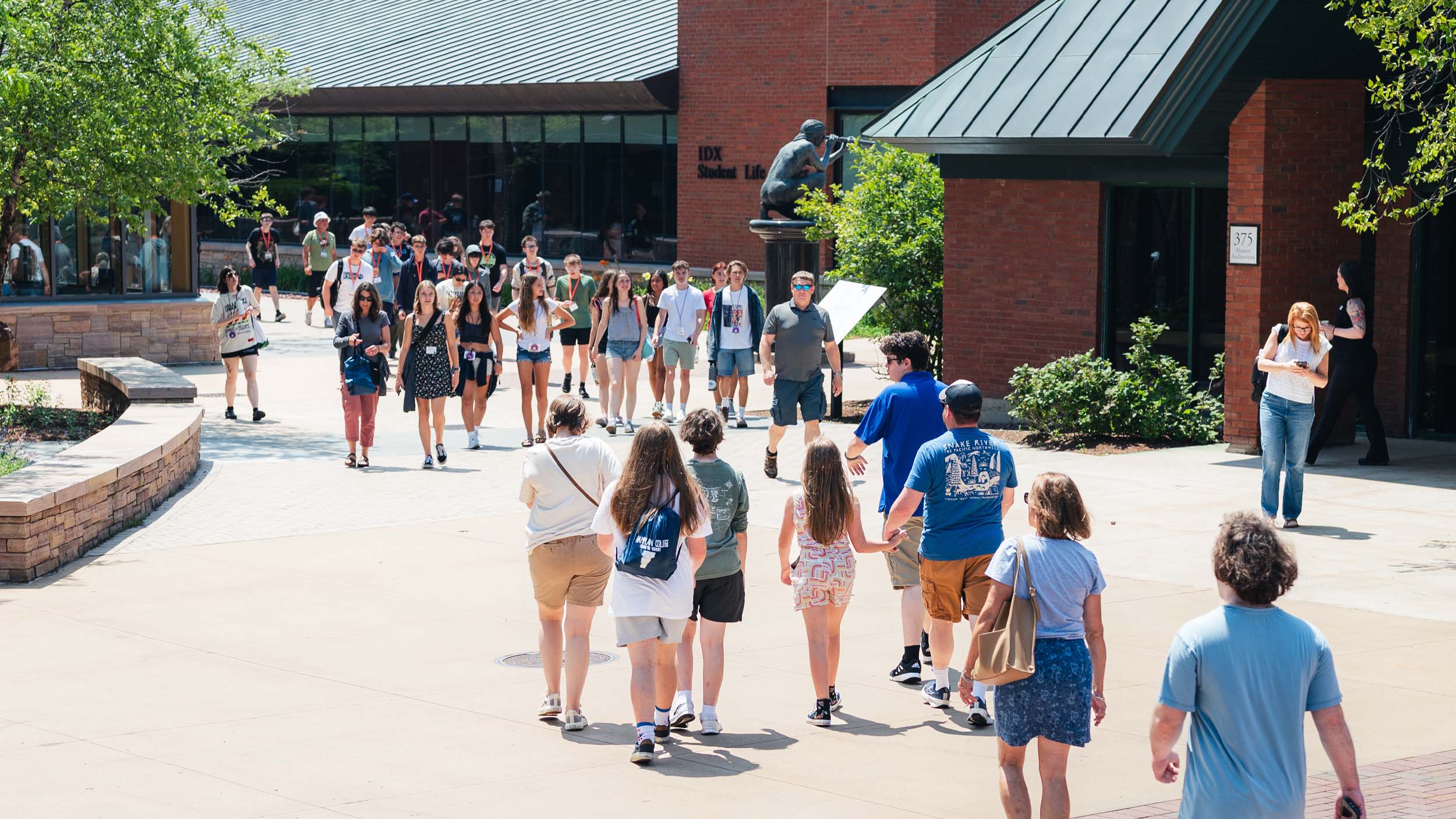 Prospective students and families visiting campus in the Summer, walking around near IDX in the courtyard