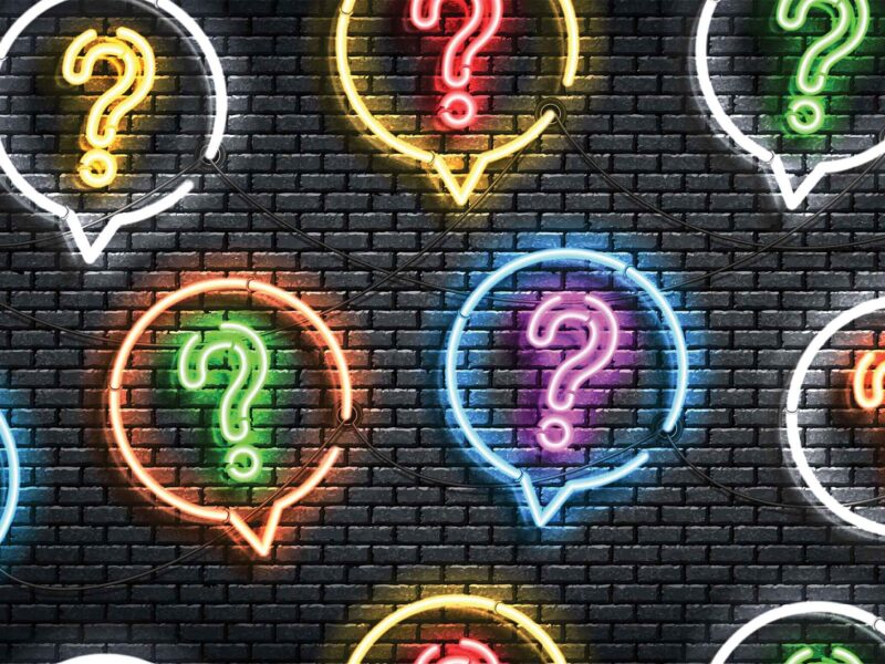 neon question marks against a dark background