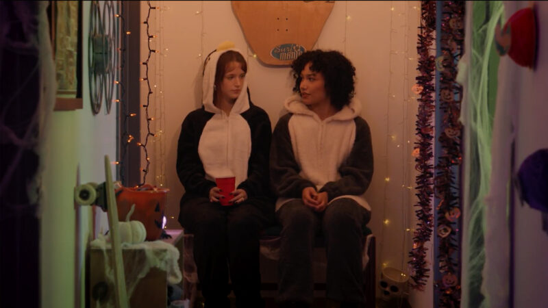 two people wearing penguin costumes in a hallway