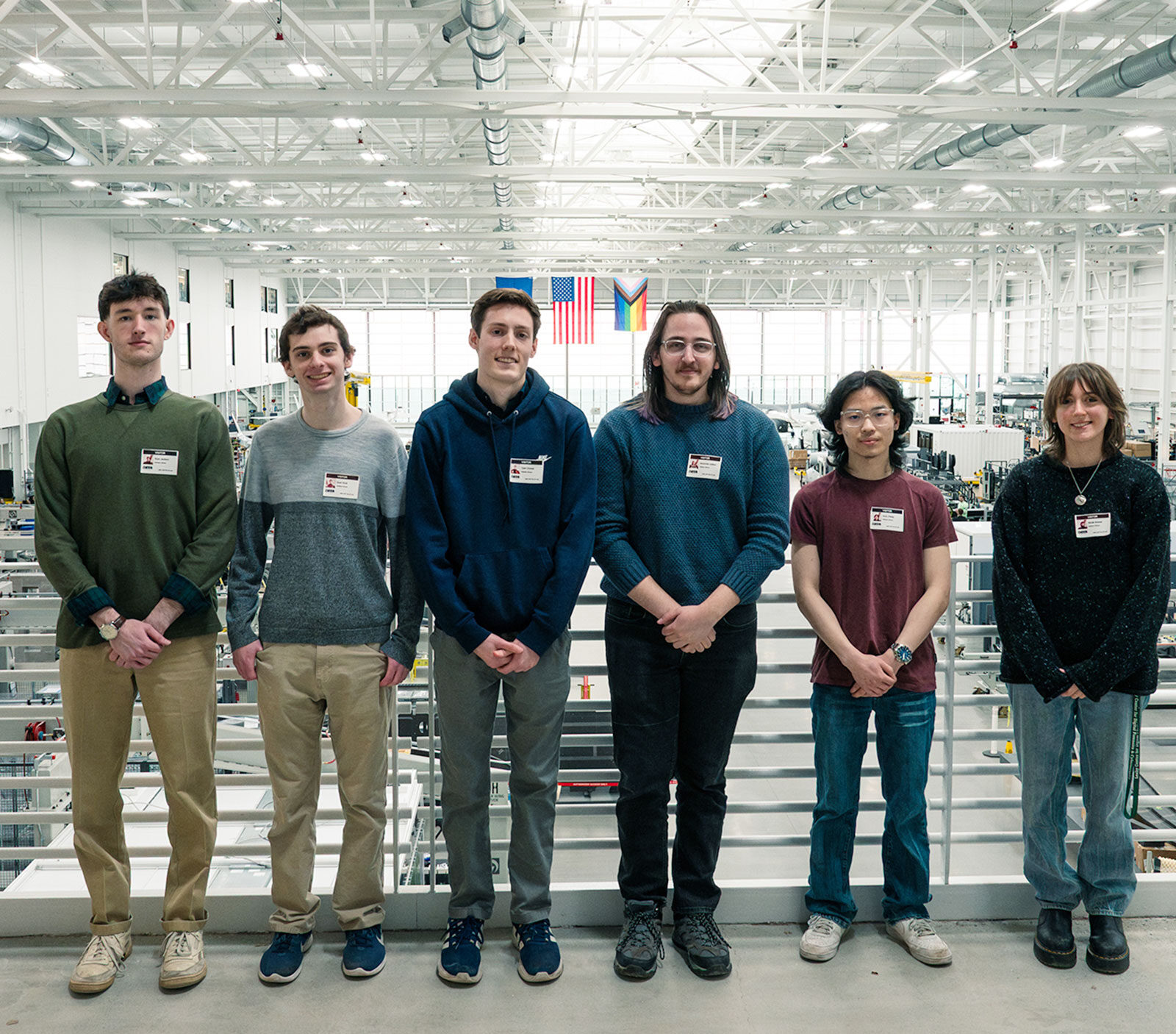 Six Champlain students pose in the hangar at BETA Technologies in Burlington, Vermont.