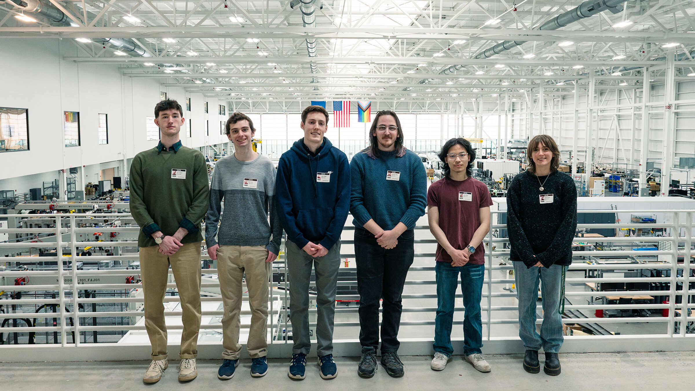 Six Champlain students pose in the hangar at BETA Technologies in Burlington, Vermont.
