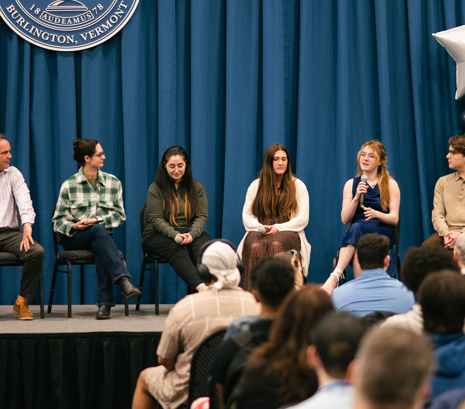 A panel discussion in front of an audience.