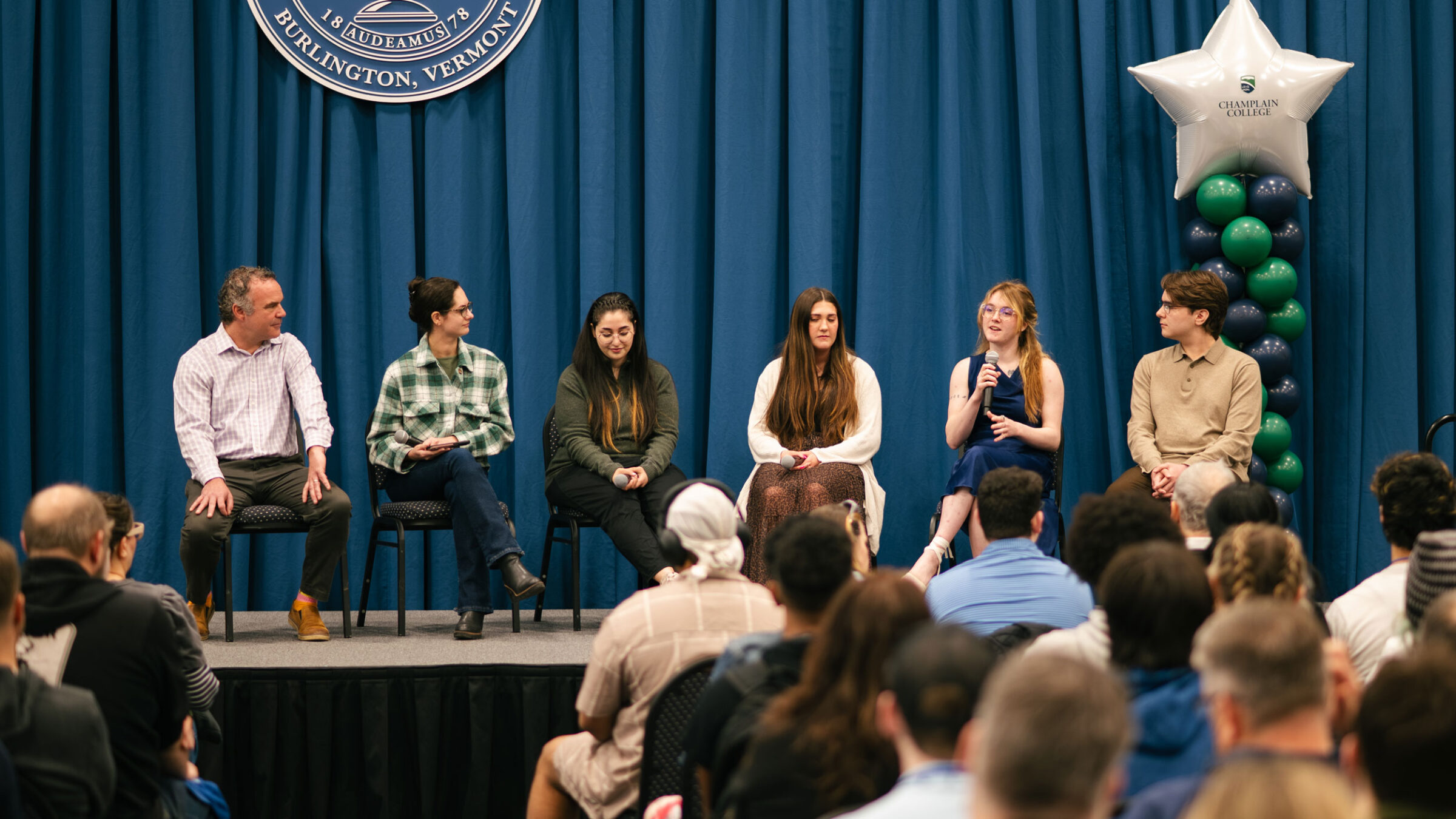 A panel discussion in front of an audience.