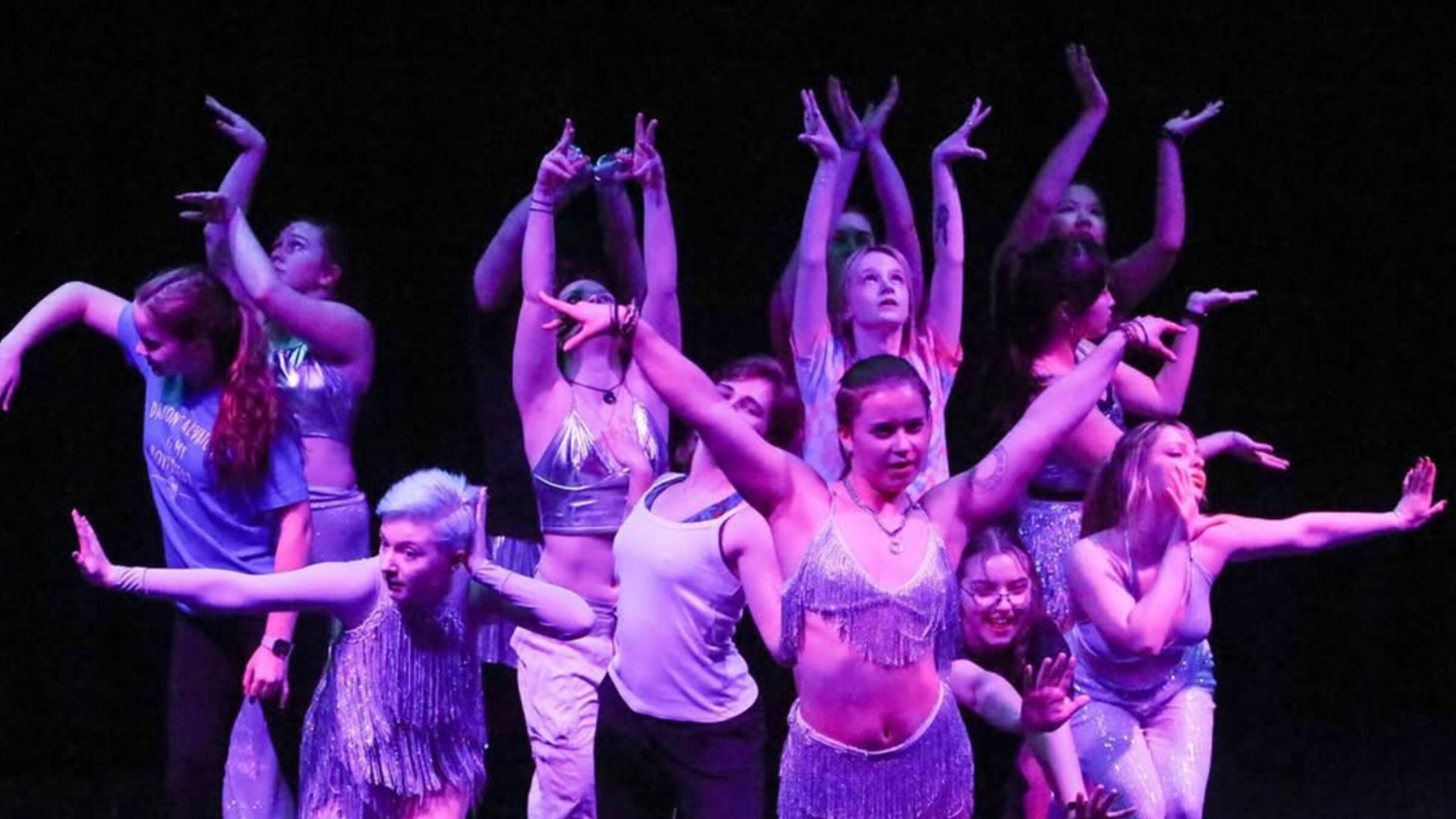 dance team members on stage in a performance posing as a group