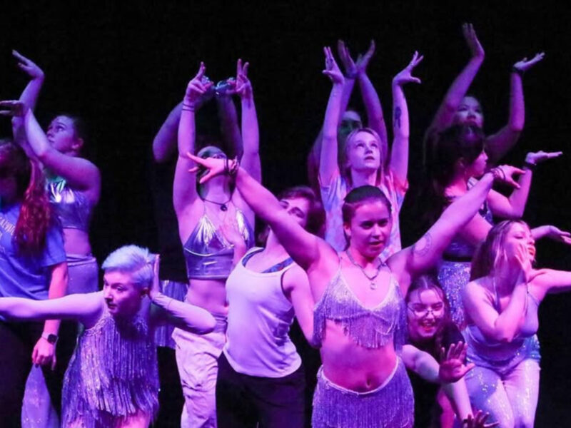 dance team members on stage in a performance posing as a group