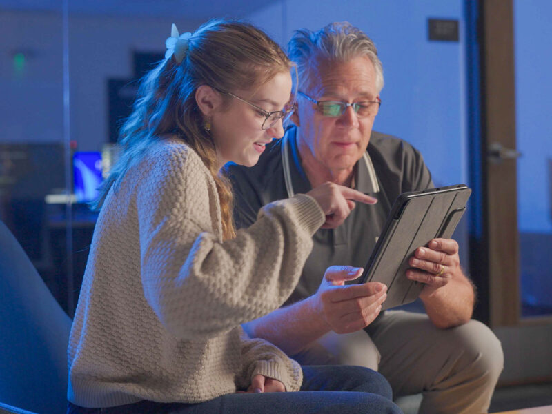 Student and faculty looking at iPad